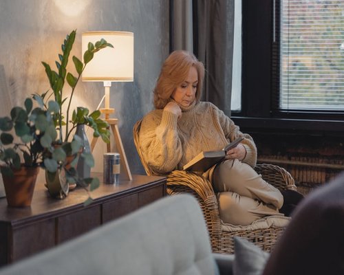 Reading a book in a cozy chair with warm lamp light