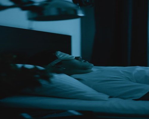 A dark, calm bedroom setting designed for deep rest
